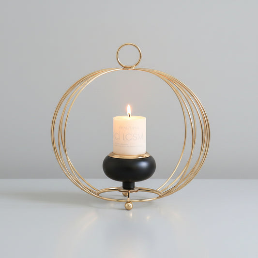 Hand holding a lit candle inside a decorative gold cage against a dark background